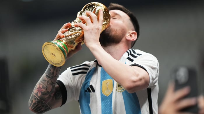 Lionel Messi kisses the World Cup trophy